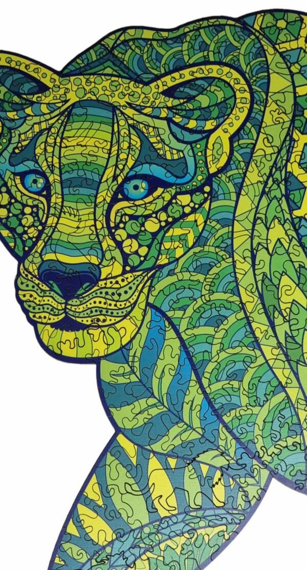 Close-up of face of big cat leopard shaped jigsaw puzzle with yellow, green and blue patterns